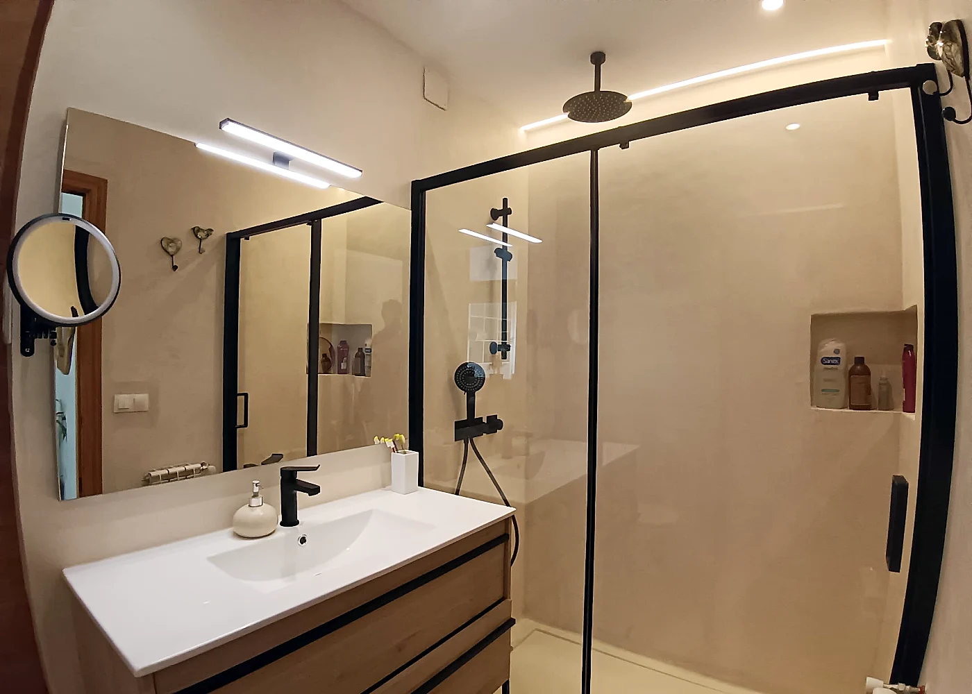 Baño principal con ducha continua a ras de suelo y grifería empotrada en Madrid